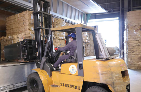 プレス加工した古紙をトラックへ積載